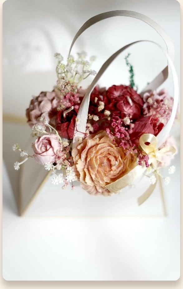 Rose and hydrangea wax bouquet arranged in a miniature purse stand